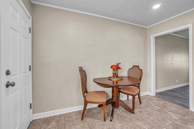 dining area featuring ornamental molding, a textured wall, baseboards, and light tile patterned floors