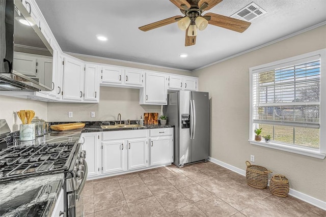 kitchen featuring crown molding, stainless steel appliances, dark countertops, visible vents, and a sink