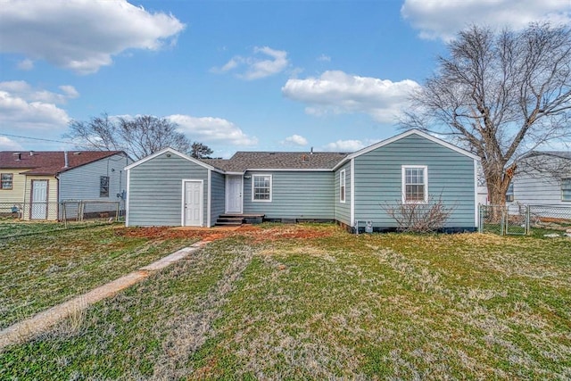 rear view of property featuring a lawn, fence, and a gate