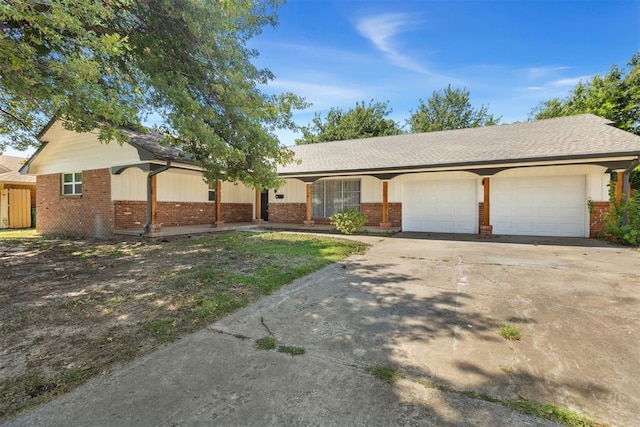 single story home featuring a garage, concrete driveway, and brick siding