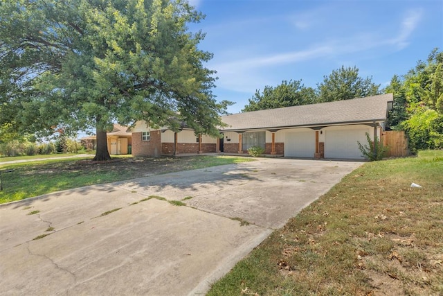 ranch-style home featuring a garage, brick siding, driveway, and a front lawn