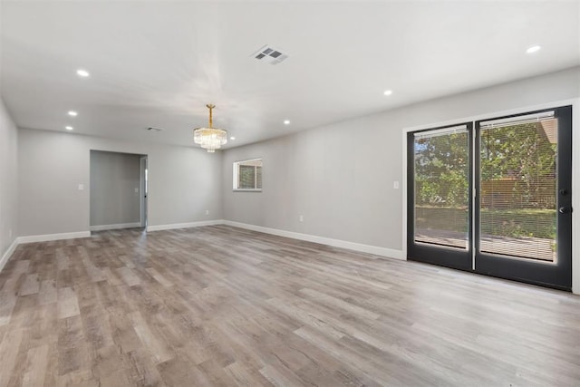 spare room with recessed lighting, visible vents, a chandelier, light wood-type flooring, and baseboards