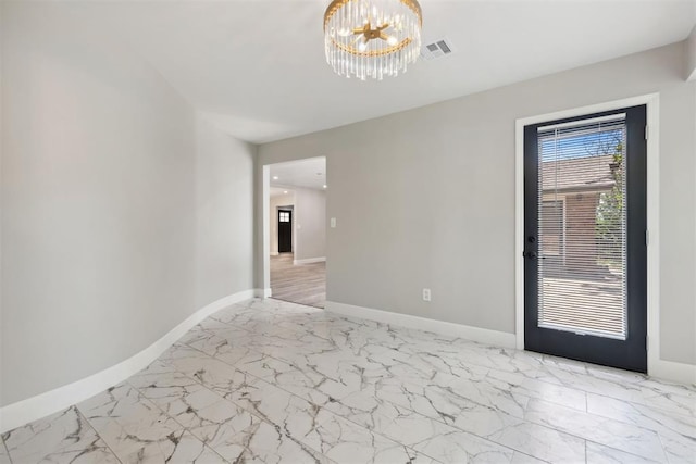 spare room with marble finish floor, baseboards, and an inviting chandelier