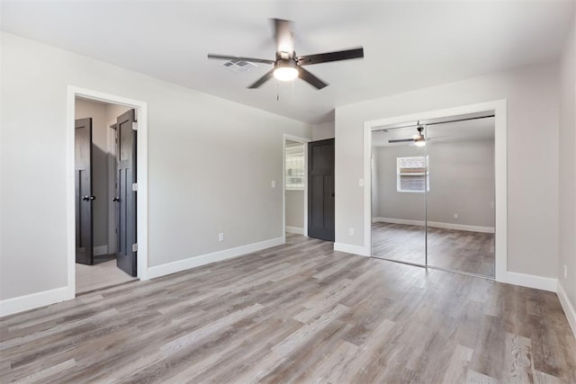 unfurnished bedroom with light wood finished floors, a closet, visible vents, and baseboards