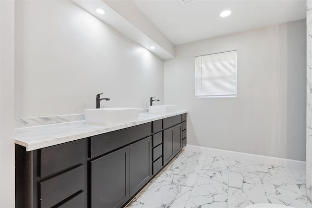 full bath featuring marble finish floor, baseboards, a sink, and recessed lighting