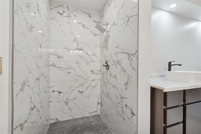 bathroom featuring recessed lighting, vanity, and a marble finish shower