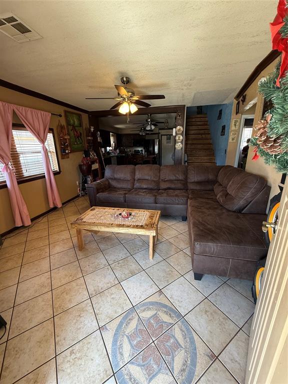 505 SE 18th St, Oklahoma City, OK 73129 - living room featuring light tile patterned floors, ceiling fan, stairway, and visible vents