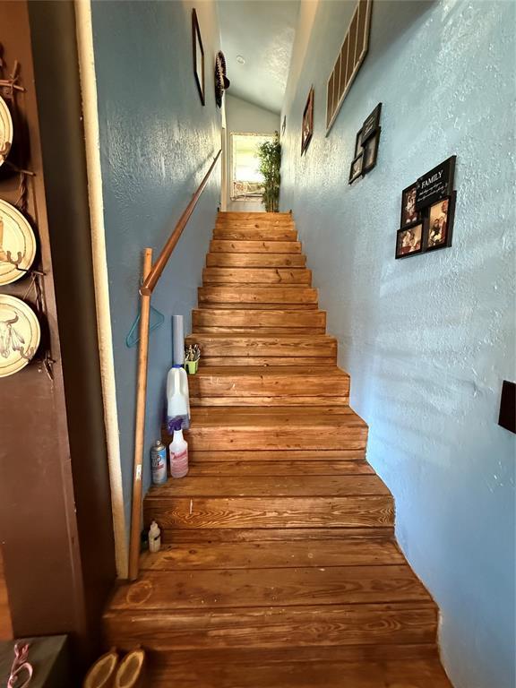 505 SE 18th St, Oklahoma City, OK 73129 - stairs featuring vaulted ceiling and a textured wall