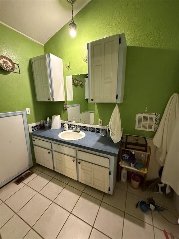 505 SE 18th St, Oklahoma City, OK 73129 - bathroom featuring visible vents, a textured wall, tile patterned flooring, vaulted ceiling, and vanity