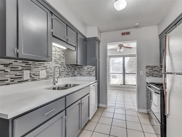 kitchen with electric stove, visible vents, gray cabinetry, a sink, and dishwasher