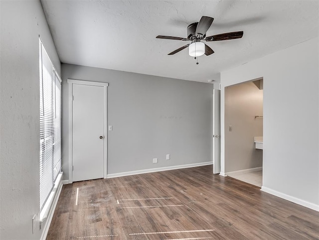 spare room with ceiling fan, wood finished floors, and baseboards