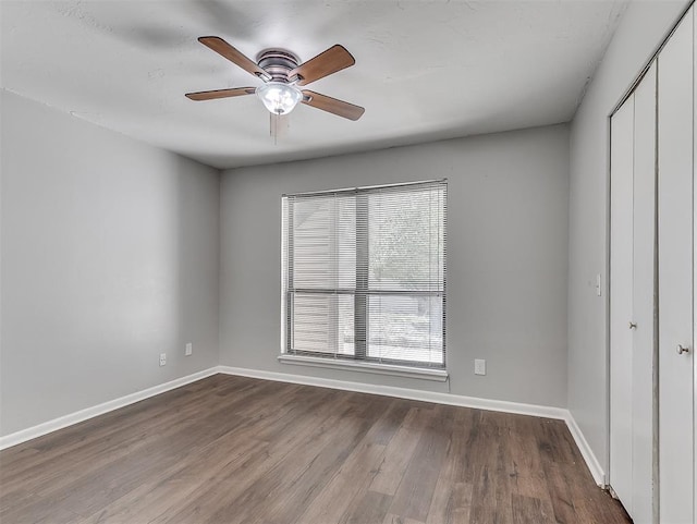 empty room featuring a ceiling fan, baseboards, and wood finished floors