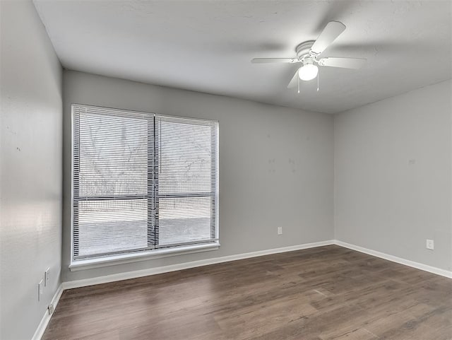 empty room with a ceiling fan, baseboards, and wood finished floors