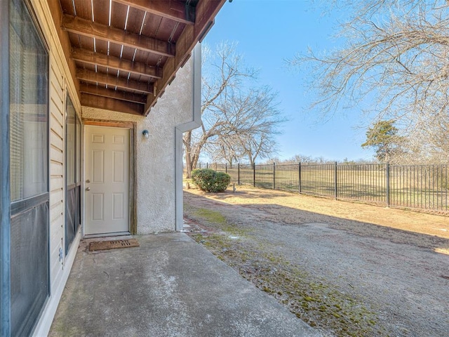 view of exterior entry featuring fence and stucco siding