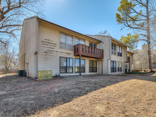 back of house featuring central air condition unit and a balcony