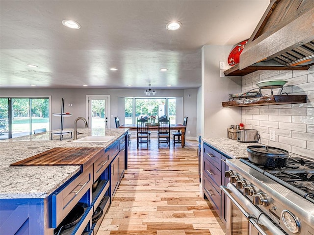 kitchen featuring a sink, light wood-type flooring, high end stainless steel range oven, a wealth of natural light, and open shelves