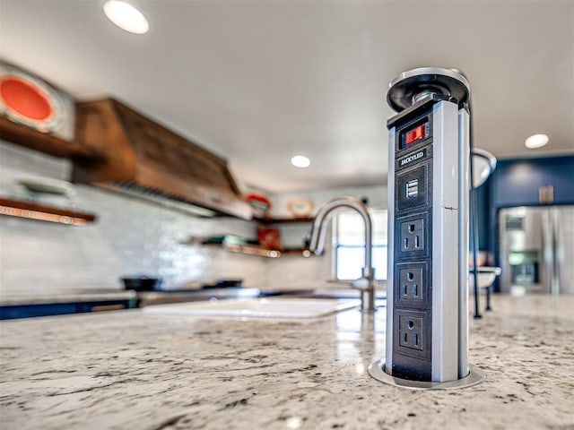 room details featuring blue cabinetry, stainless steel refrigerator with ice dispenser, and recessed lighting