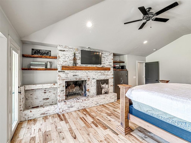 bedroom featuring recessed lighting, a brick fireplace, vaulted ceiling, and wood finished floors