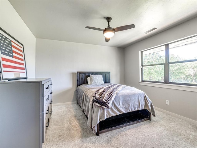 bedroom with a ceiling fan, light colored carpet, visible vents, and baseboards