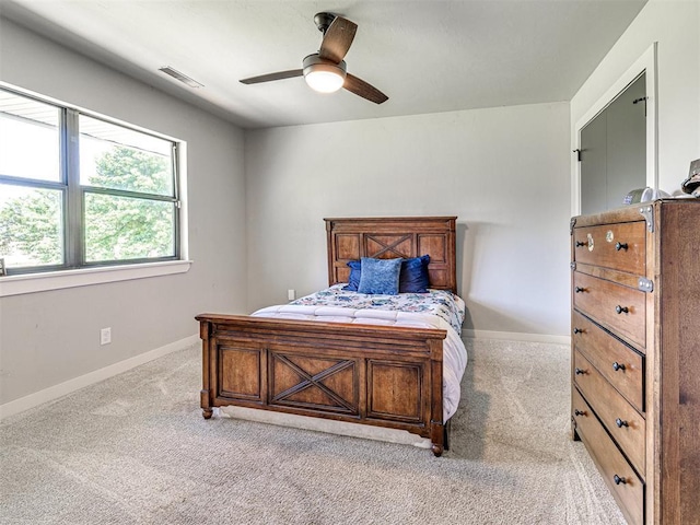 bedroom with visible vents, light carpet, and baseboards