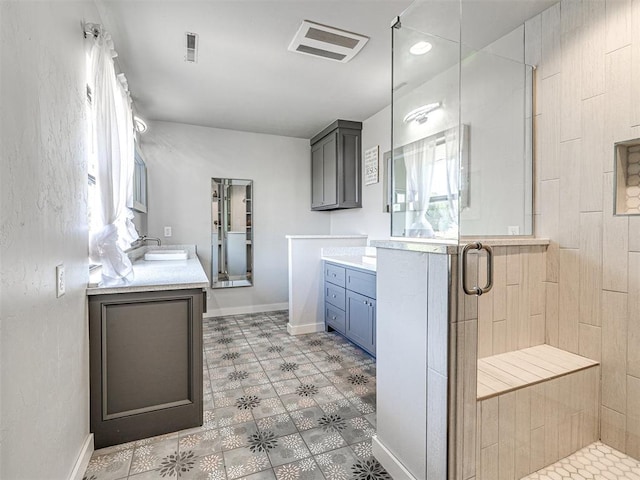 bathroom featuring a stall shower, two vanities, a sink, and visible vents