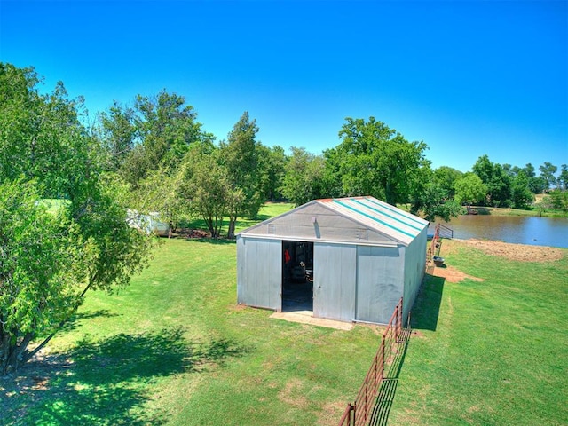 view of pole building featuring a lawn and a water view