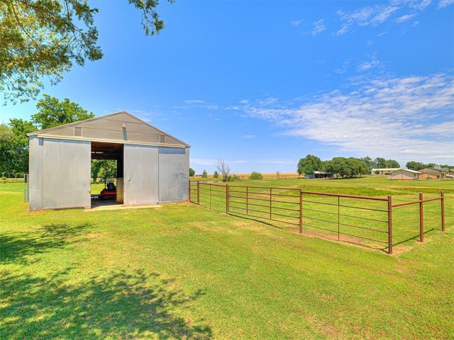 view of yard with an outbuilding, a rural view, and fence