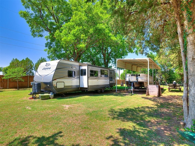 view of yard with fence and a carport