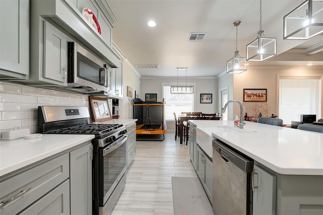 kitchen featuring crown molding, stainless steel appliances, visible vents, and gray cabinetry