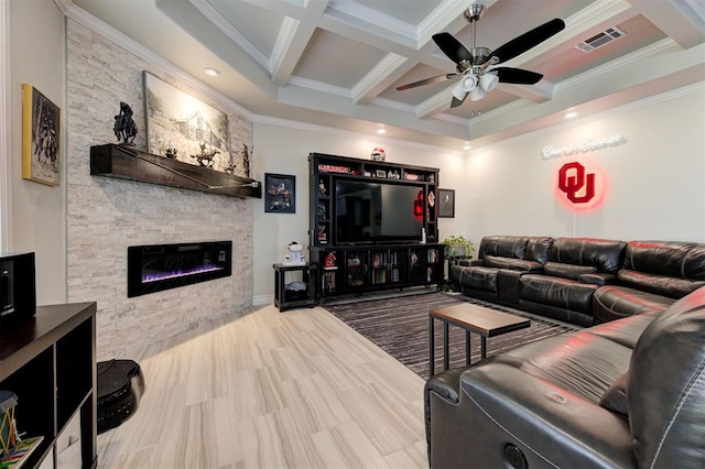 living area featuring a stone fireplace, coffered ceiling, visible vents, a ceiling fan, and beamed ceiling