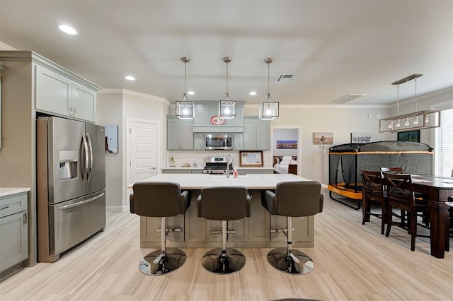 kitchen with tasteful backsplash, light countertops, appliances with stainless steel finishes, and gray cabinetry