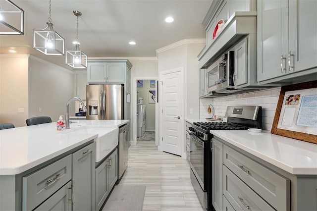 kitchen with appliances with stainless steel finishes, gray cabinets, and a sink