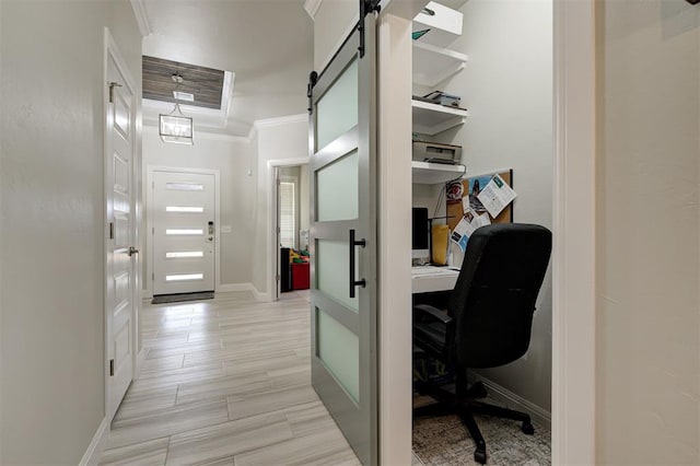 office space featuring ornamental molding, a barn door, wood finish floors, and baseboards