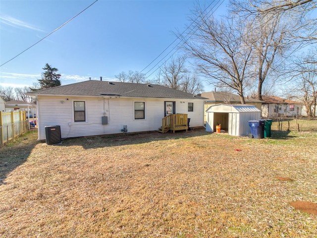 back of house with central air condition unit, a storage unit, a lawn, fence private yard, and an outdoor structure