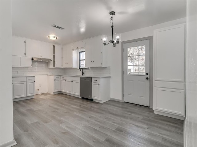 kitchen with a sink, light wood finished floors, tasteful backsplash, and stainless steel dishwasher