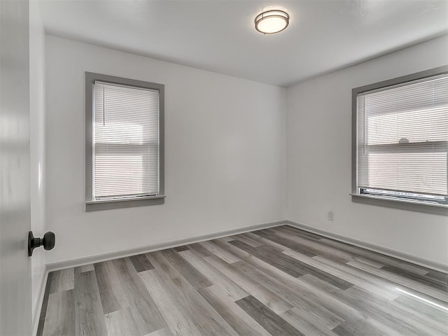 spare room with wood finished floors and baseboards