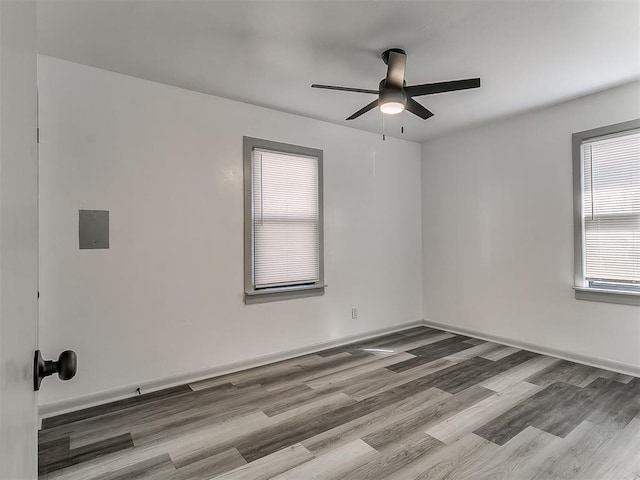 empty room with ceiling fan, baseboards, and wood finished floors