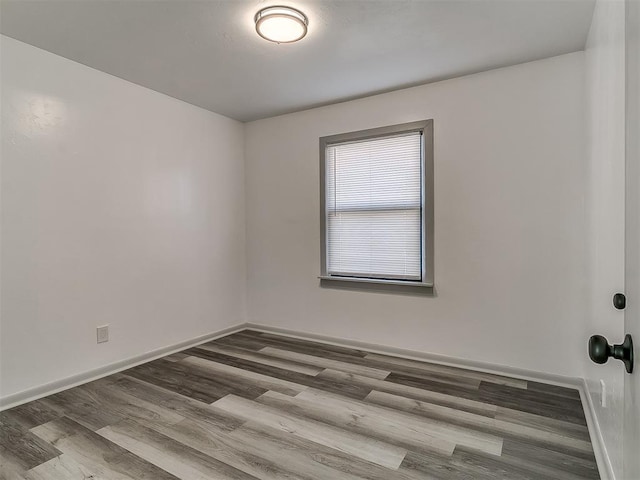 unfurnished room featuring baseboards and wood finished floors