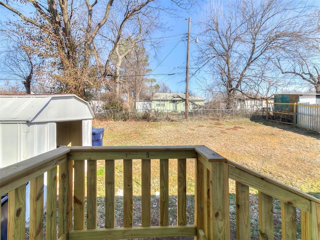 wooden terrace with a shed, an outdoor structure, and a fenced backyard