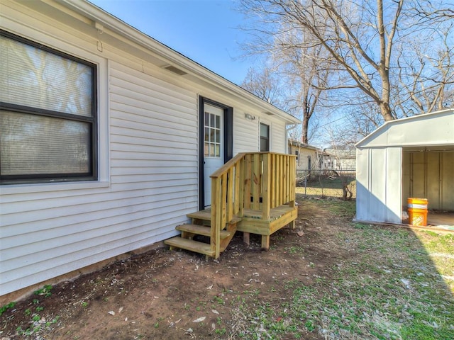 view of yard with fence, a storage unit, and an outdoor structure