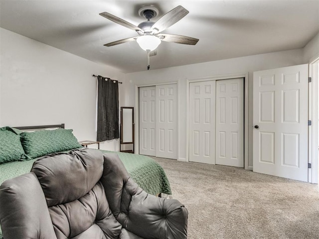 bedroom featuring multiple closets, carpet flooring, and ceiling fan