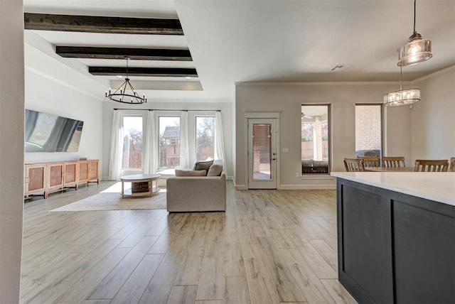 unfurnished living room with light wood-style floors, a chandelier, and a wealth of natural light