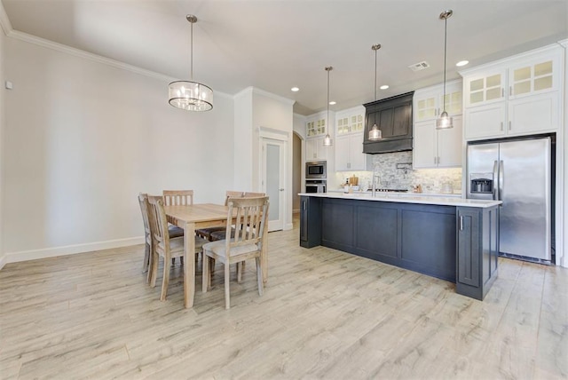 kitchen featuring crown molding, stainless steel appliances, tasteful backsplash, light countertops, and white cabinets