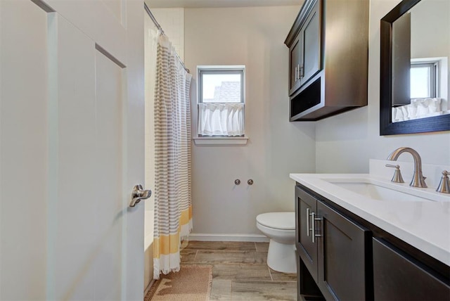 full bathroom featuring toilet, wood finished floors, vanity, baseboards, and shower / bath combo