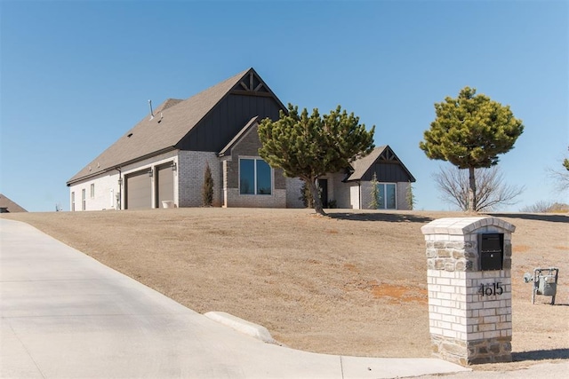 view of front of house with board and batten siding, brick siding, and an attached garage