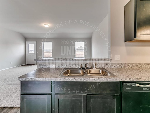 kitchen with carpet floors, a peninsula, a sink, light countertops, and dishwasher