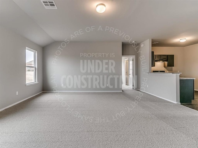 unfurnished living room featuring carpet floors, lofted ceiling, visible vents, and baseboards