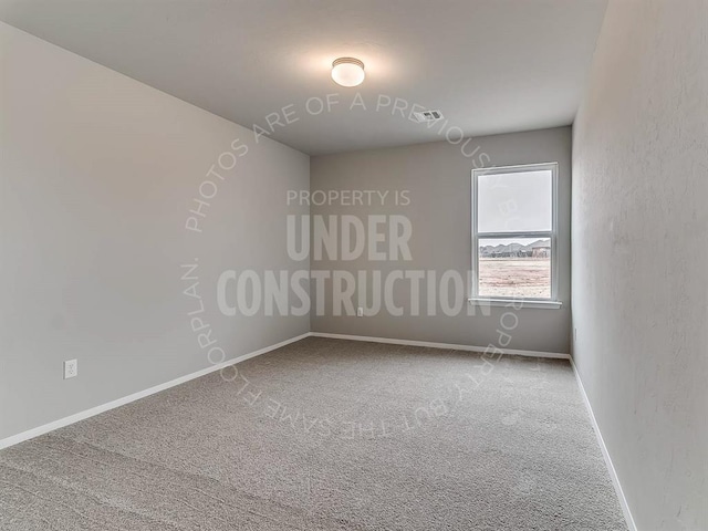 carpeted spare room with visible vents and baseboards