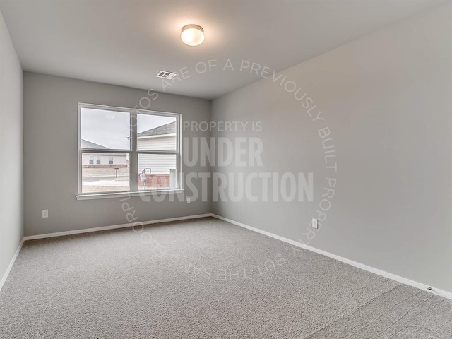 carpeted spare room featuring visible vents and baseboards