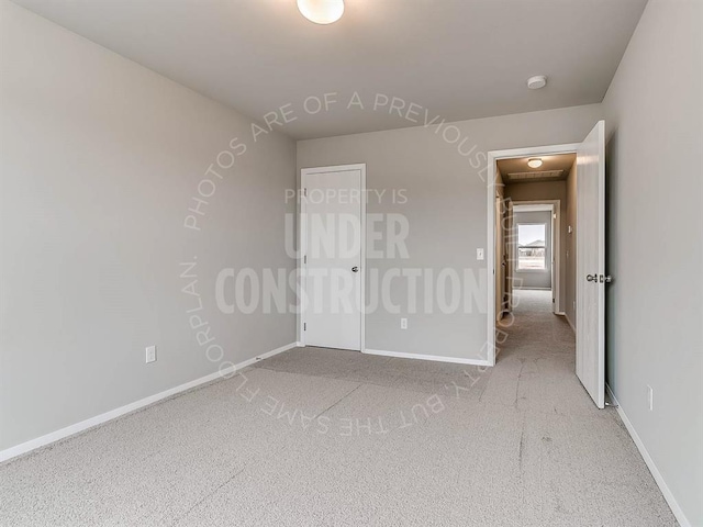 unfurnished bedroom featuring carpet floors and baseboards